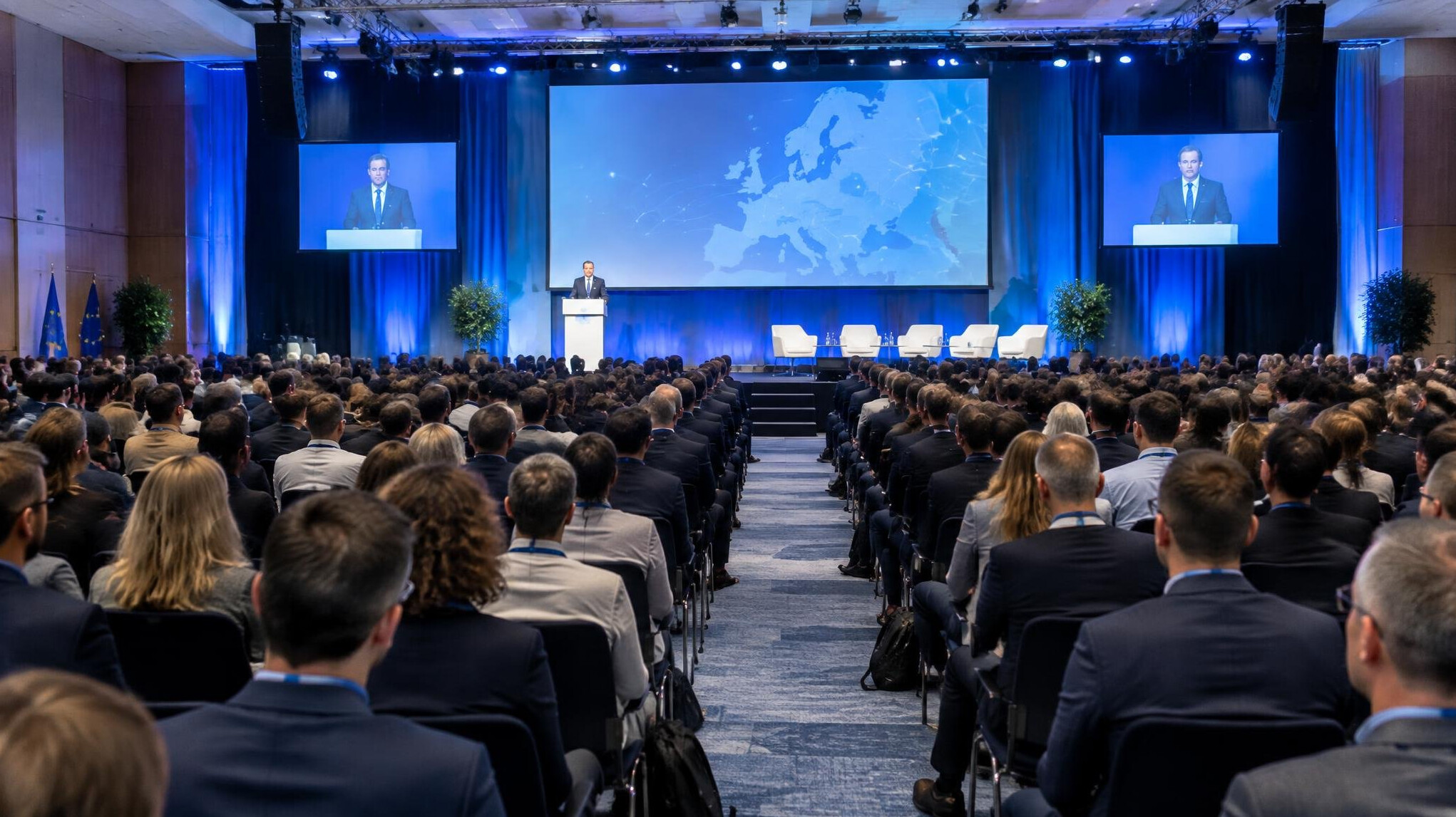 Conference hall with audience seated facing a stage